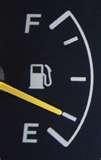 A gas guage with the needle pointing at the a mark between half and empty.